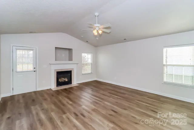 a view of empty room with fireplace and fan