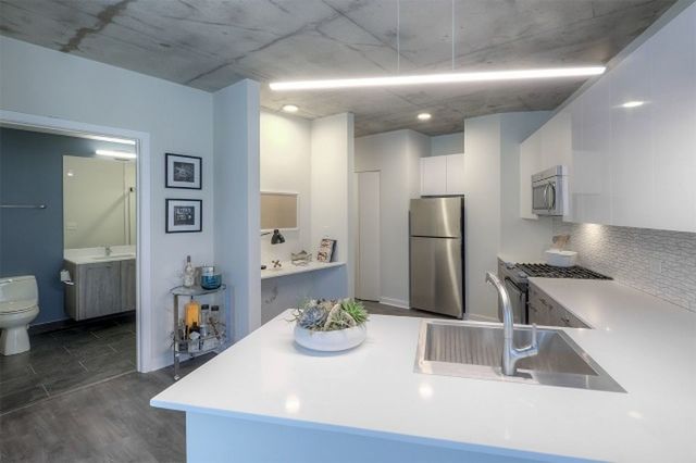 Undisclosed Address Chicago, IL 60657 - Photo 4 of 12 a kitchen with stainless steel appliances granite countertop a sink and a refrigerator