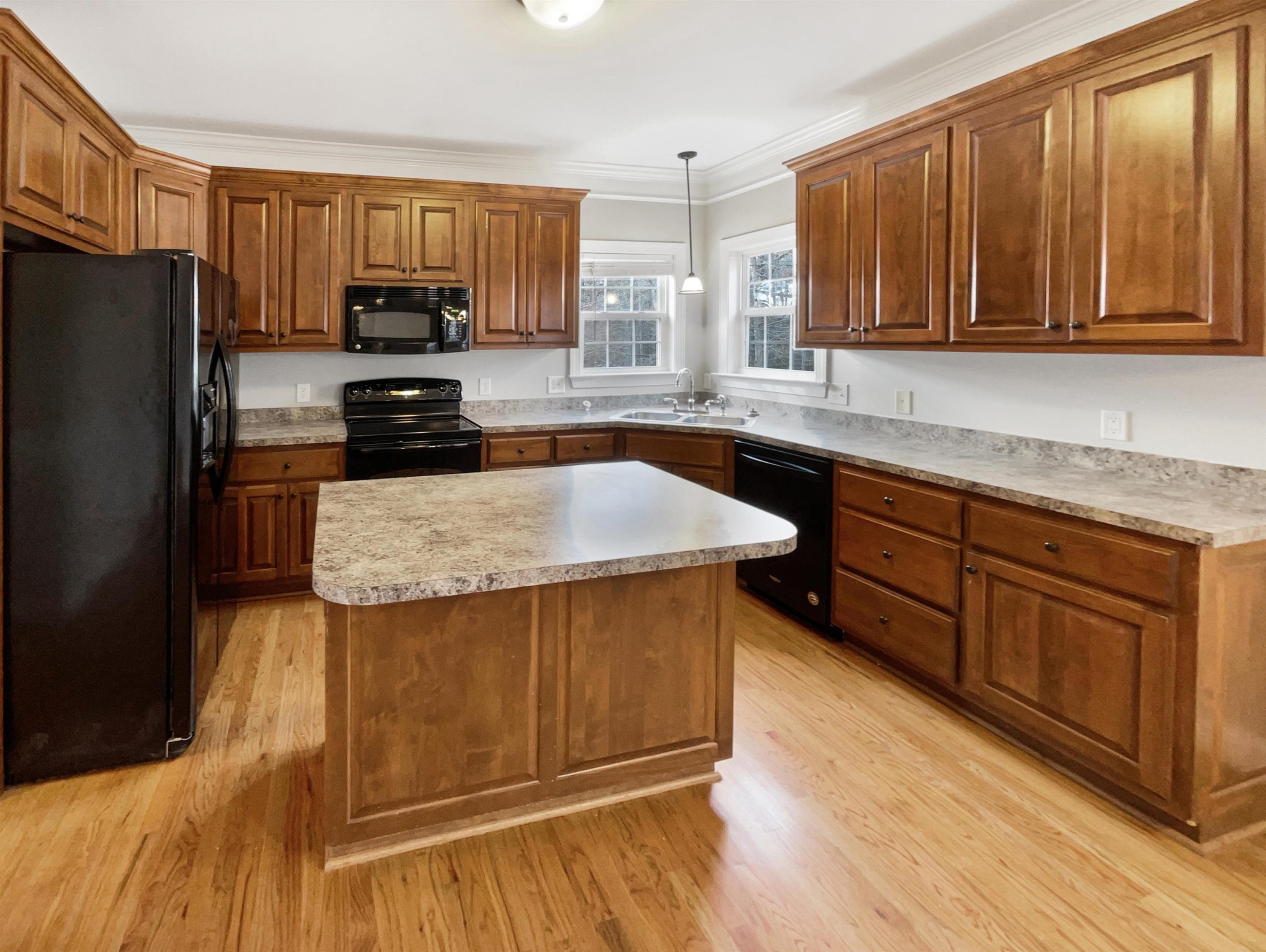 90 Bertram Drive Clayton, NC 27520 - Photo 7 of 19 a kitchen with stainless steel appliances granite countertop white cabinets a refrigerator a stove a sink and dishwasher with wooden floor