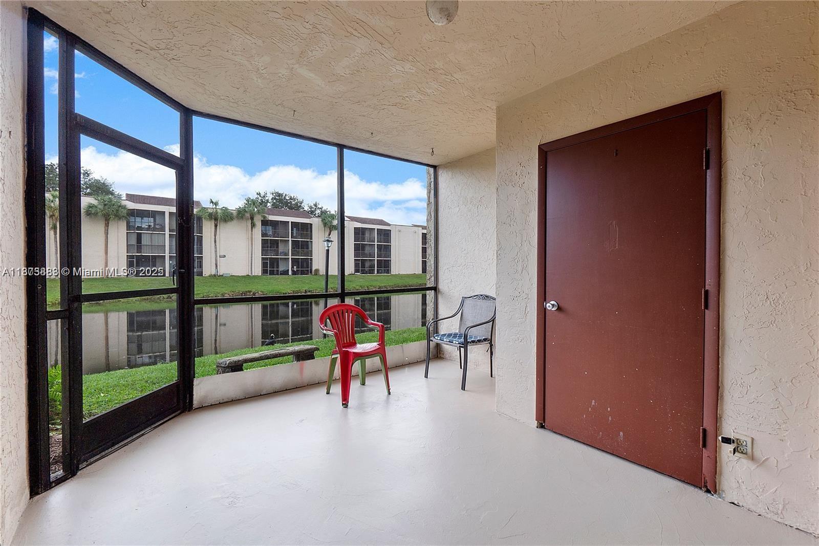 3399 Foxcroft Road, Unit 108 Miramar, FL 33025 - Photo 2 of 15 a view of a porch with furniture and floor to ceiling window