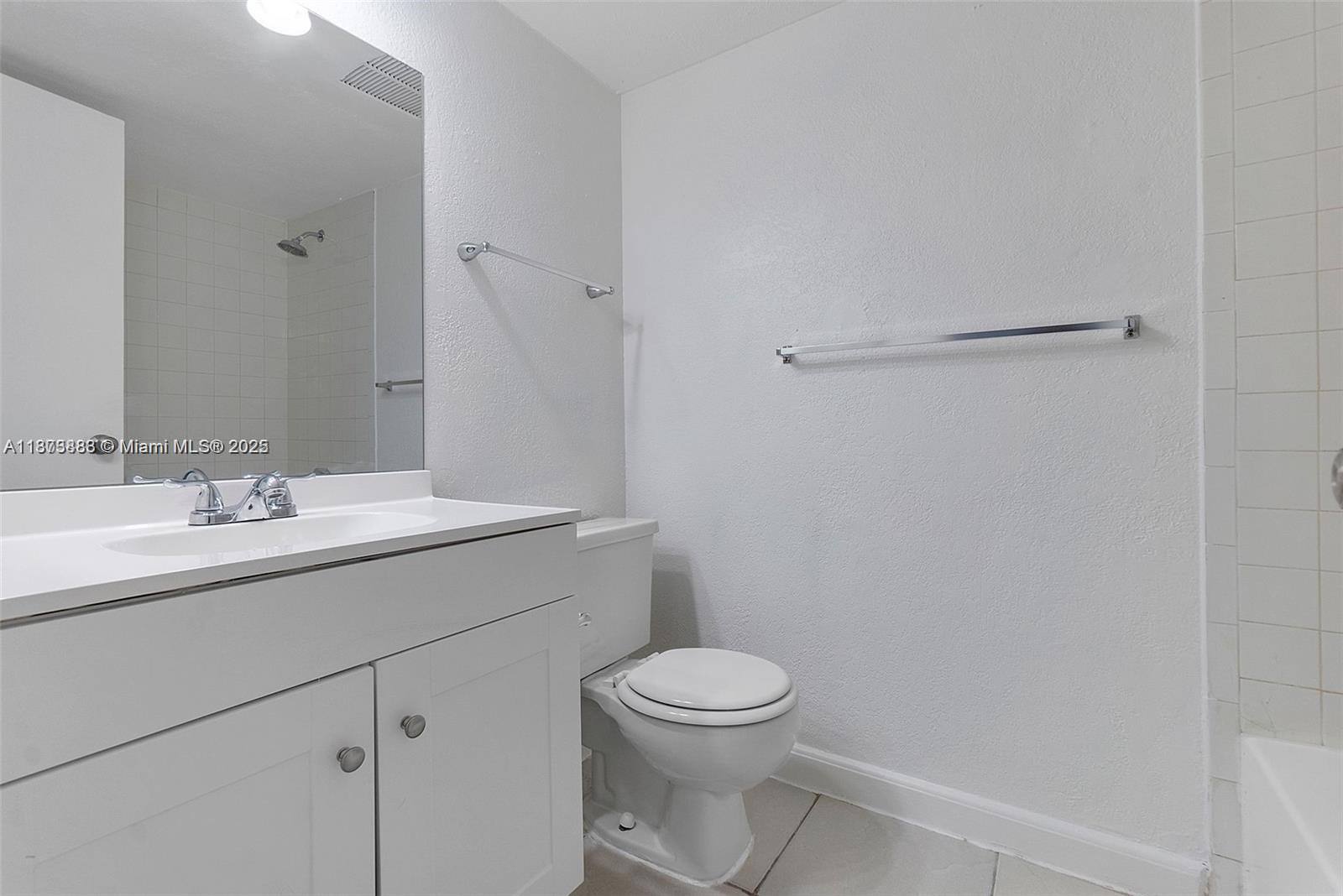 3399 Foxcroft Road, Unit 108 Miramar, FL 33025 - Photo 7 of 15 a bathroom with a granite countertop sink a toilet and a mirror