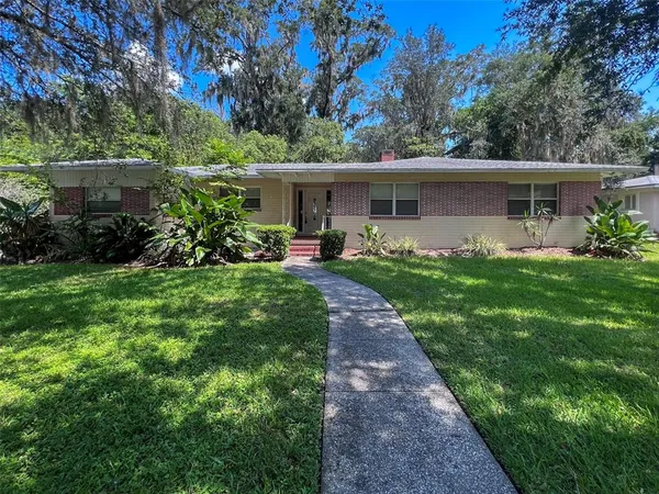 a front view of a house with a yard and trees