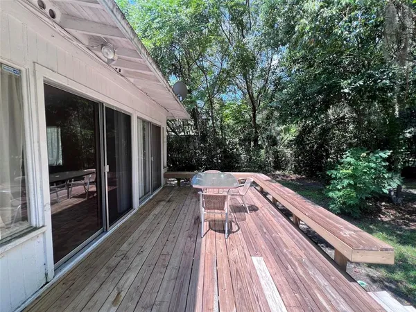 a balcony with wooden floor and outdoor seating