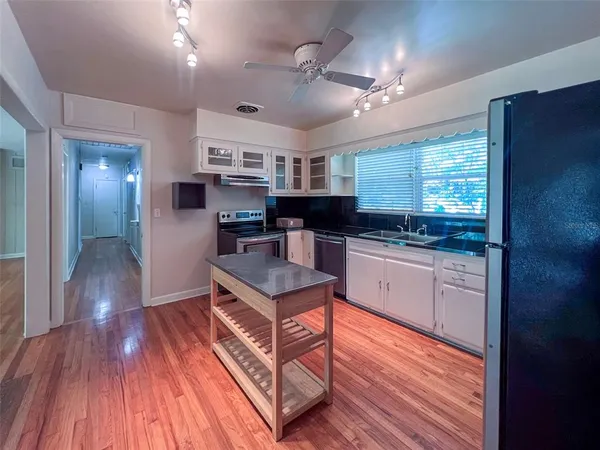 a kitchen with stainless steel appliances granite countertop a lot of counter space and wooden floors