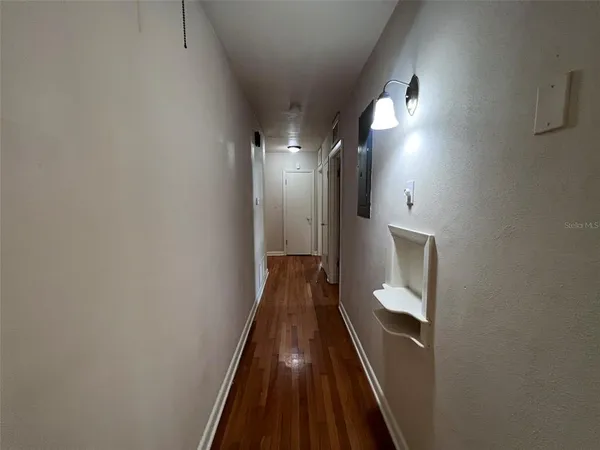 a view of a hallway with wooden floor