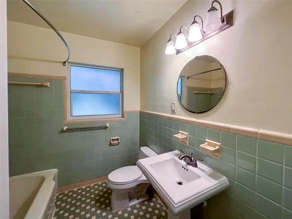 a bathroom with a sink mirror and toilet