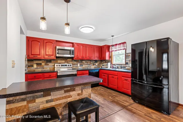 a kitchen with stainless steel appliances granite countertop a refrigerator and a stove top oven