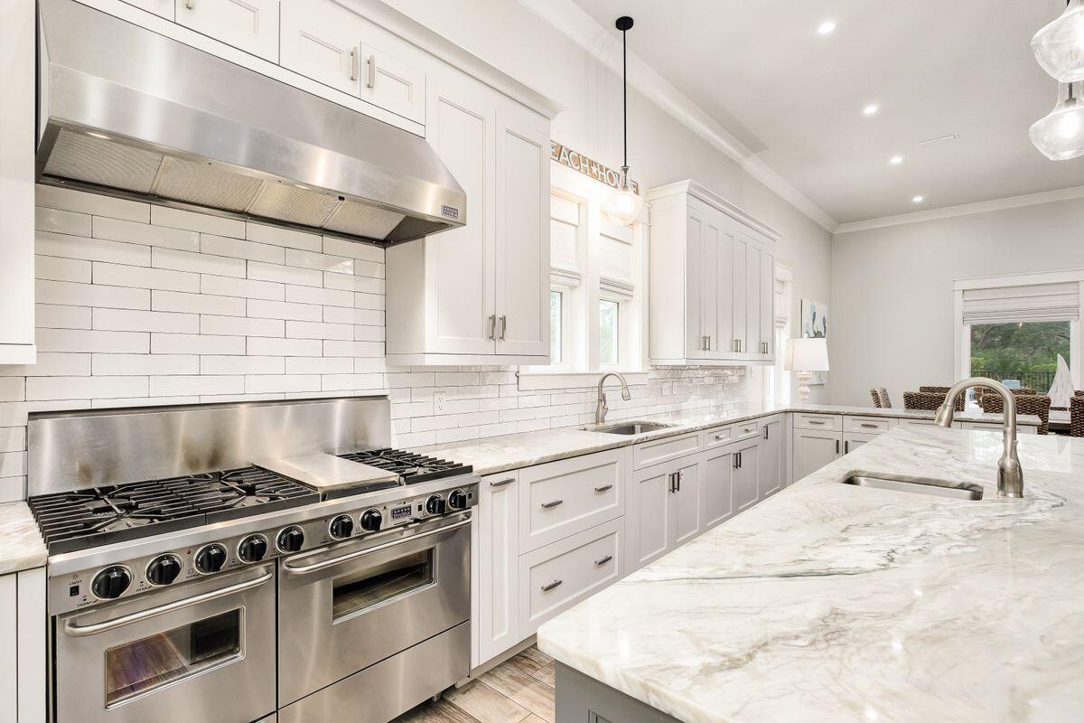 240 Overlook Drive Miramar Beach, FL 32550 - Photo 8 of 47 a large kitchen with stainless steel appliances granite countertop a stove a sink dishwasher and white cabinets with wooden floor