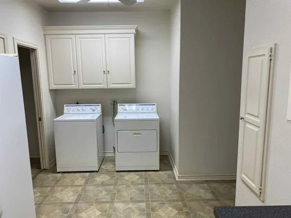 a utility room with cabinets washer and dryer