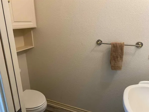 a white toilet sitting next to a white sink and vanity