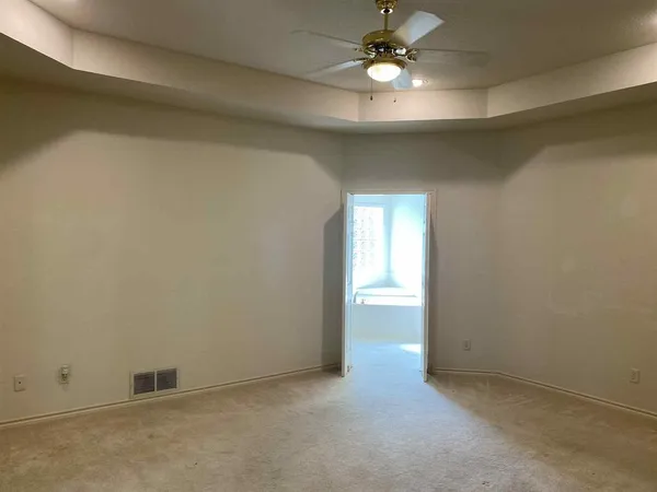 an empty room with a ceiling fan and a window