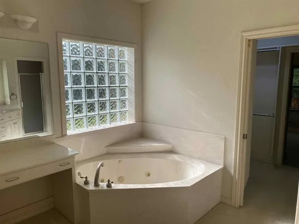 a white bath tub sitting in a bathroom next to a window