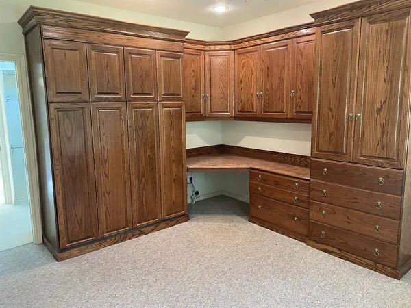 a view of a closet with wooden cabinet