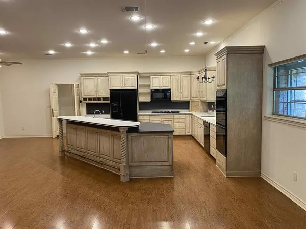 a kitchen with stainless steel appliances a refrigerator and a stove top oven