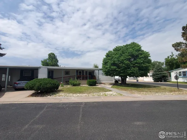 a view of a house with a yard and large trees