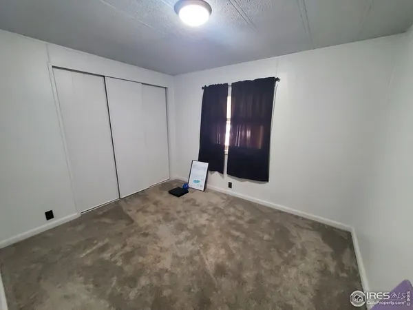 a view of an empty room with closet and entryway