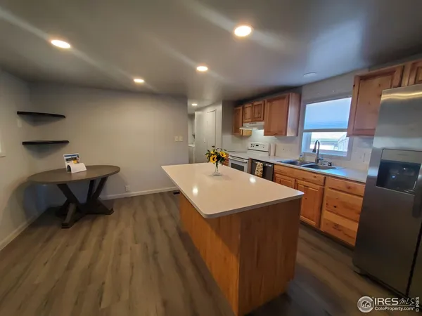 a kitchen with stainless steel appliances a sink cabinets and wooden floor