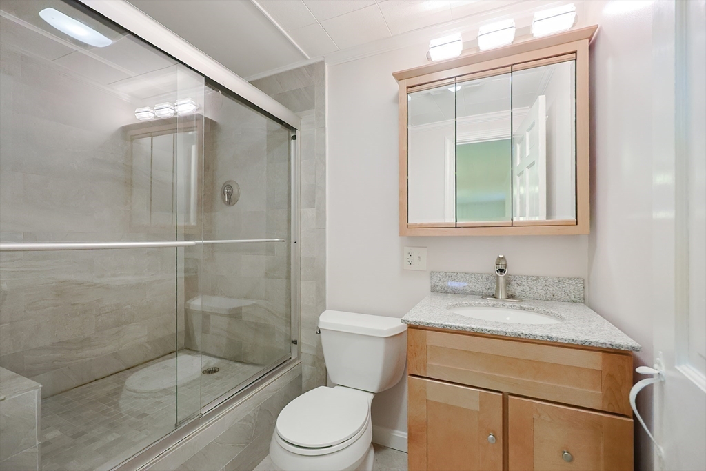 23 Pine Ridge Circle Reading, MA 01867 - Photo 36 of 42 a bathroom with a granite countertop sink a toilet and shower