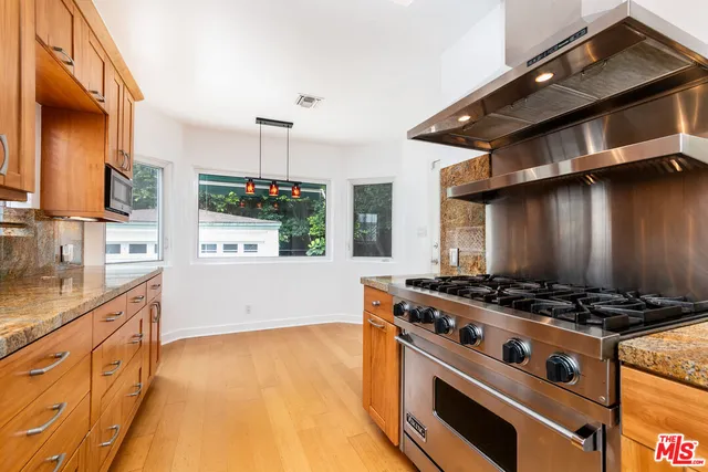 a kitchen with granite countertop a stove and a sink