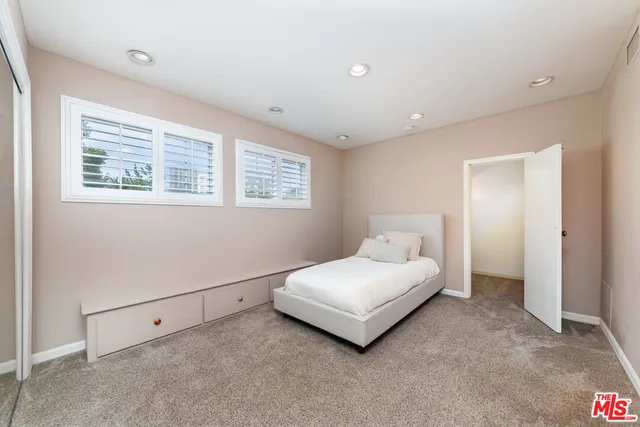 a spacious bedroom with a bed and a window