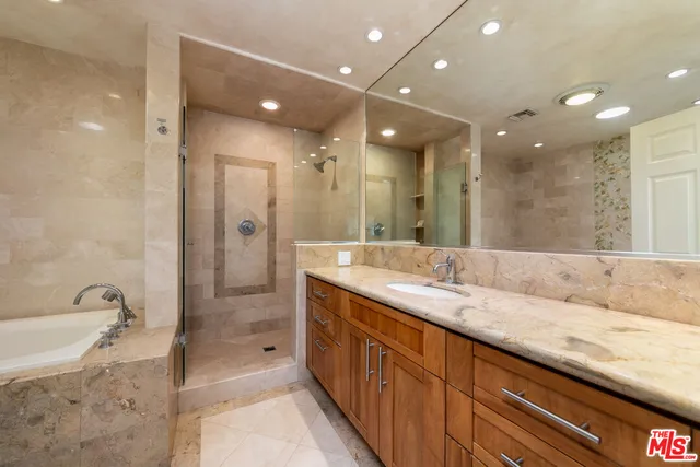 a spacious bathroom with a granite countertop sink mirror and shower