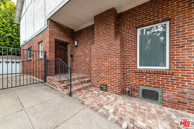 a view of a brick house with many windows