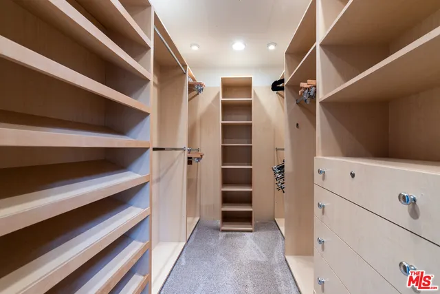 a view of walk in closet with empty racks