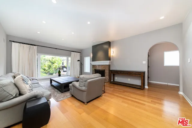a living room with furniture a large window and a fireplace