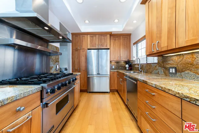 a kitchen with stainless steel appliances granite countertop a stove a sink dishwasher and a refrigerator