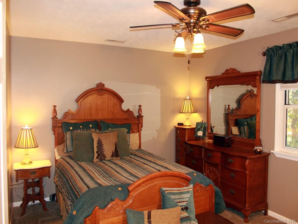 185 Loop Road Clyde, NC 28721 - Photo 12 of 24 a bedroom with a bed and a chandelier