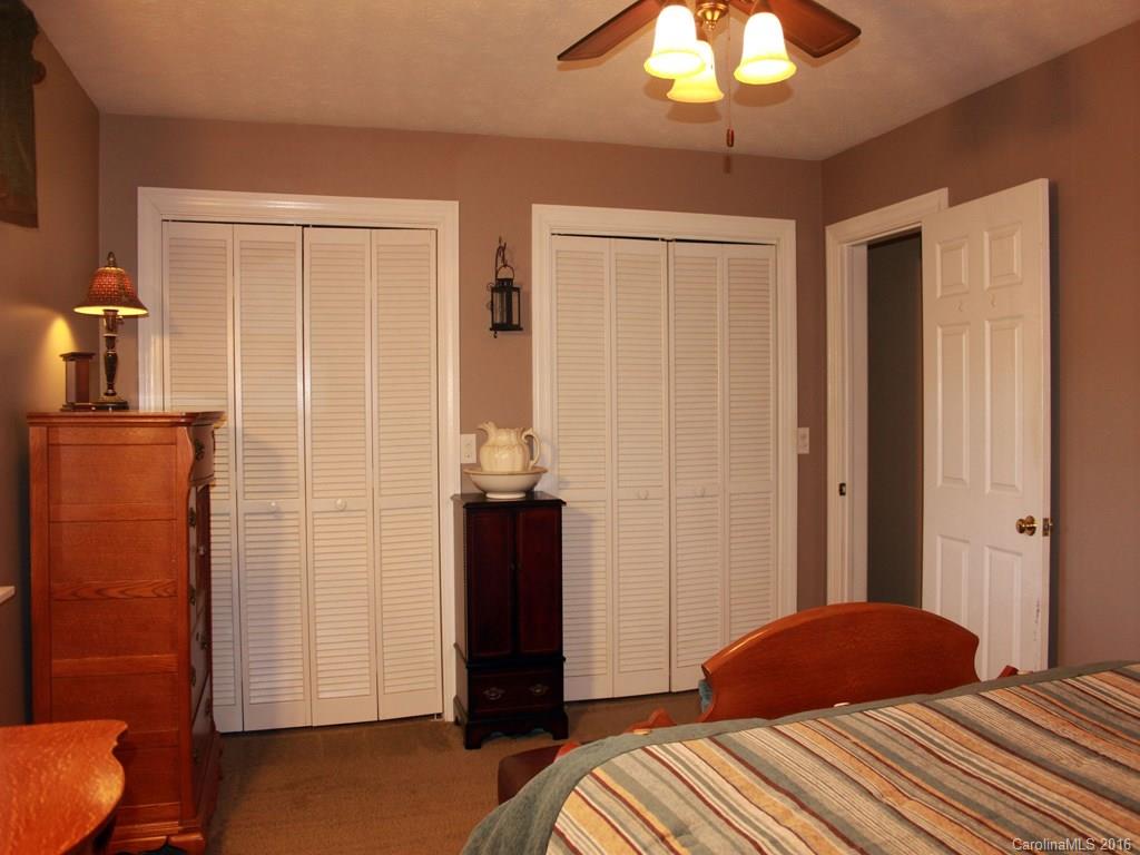 185 Loop Road Clyde, NC 28721 - Photo 13 of 24 a bedroom with a bed and a chandelier