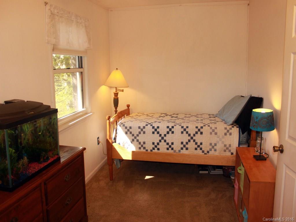 185 Loop Road Clyde, NC 28721 - Photo 15 of 24 a bed sitting in a bedroom next to a window