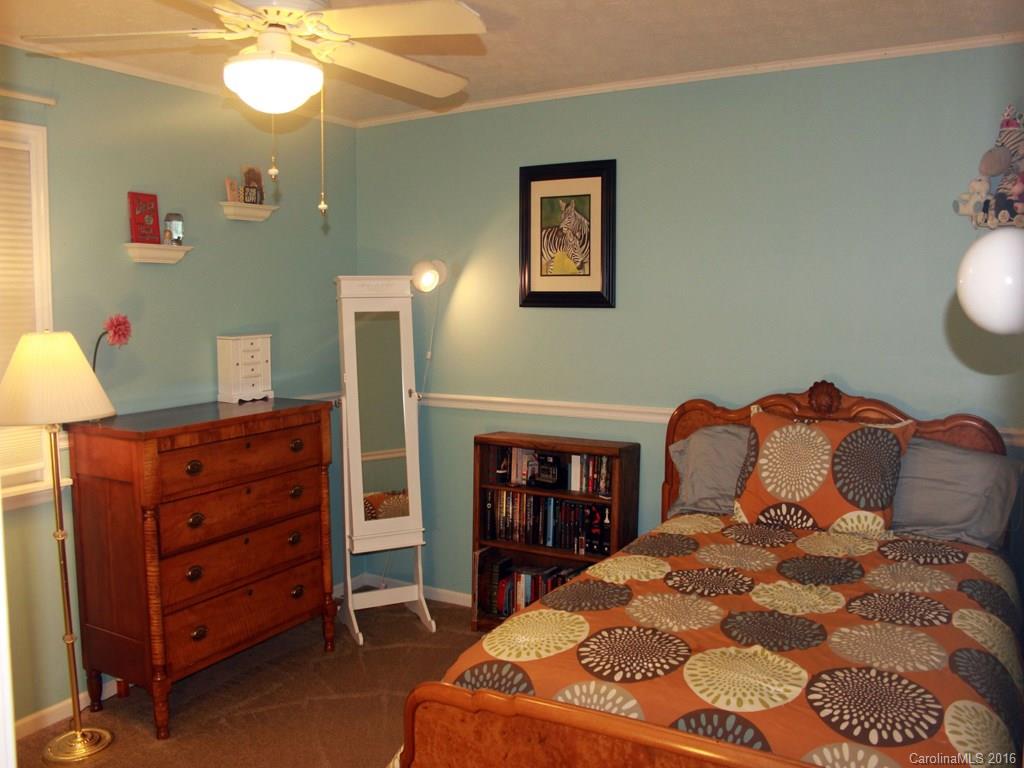 185 Loop Road Clyde, NC 28721 - Photo 6 of 24 a bedroom with a bed and a chandelier