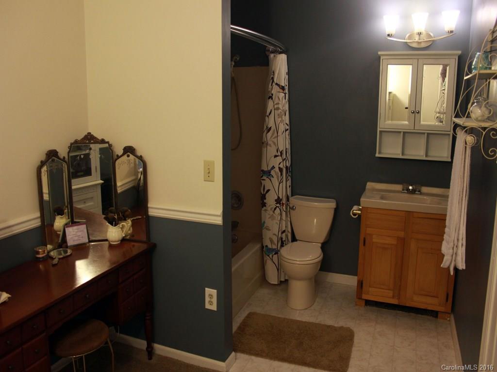 185 Loop Road Clyde, NC 28721 - Photo 9 of 24 a bathroom with a toilet a sink and mirror