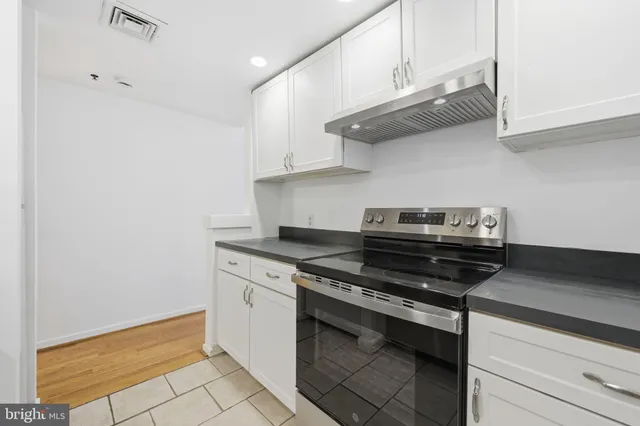 a stove top oven sitting inside of a kitchen