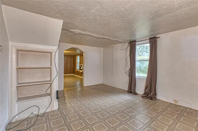 a view of an empty room with cabinet and a window
