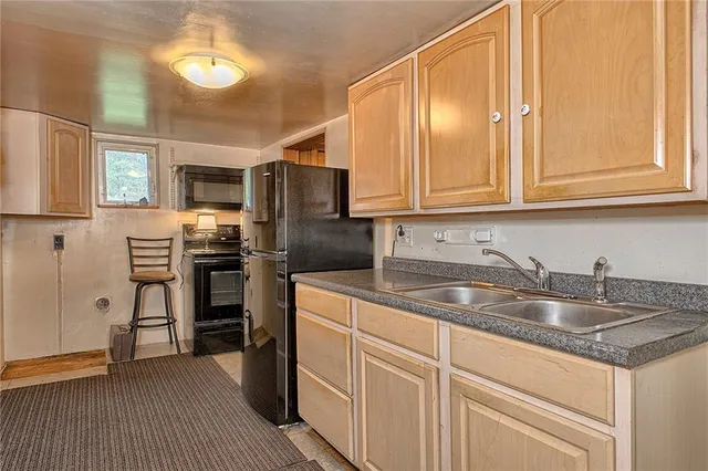 a kitchen with stainless steel appliances granite countertop a sink a stove and refrigerator