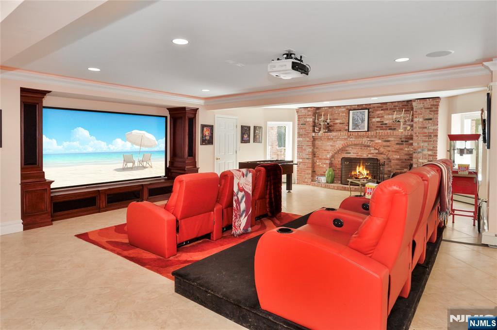 14 Werimus Brook Road Saddle River, NJ 07458 - Photo 45 of 50 a living room with furniture a projector and a flat screen tv