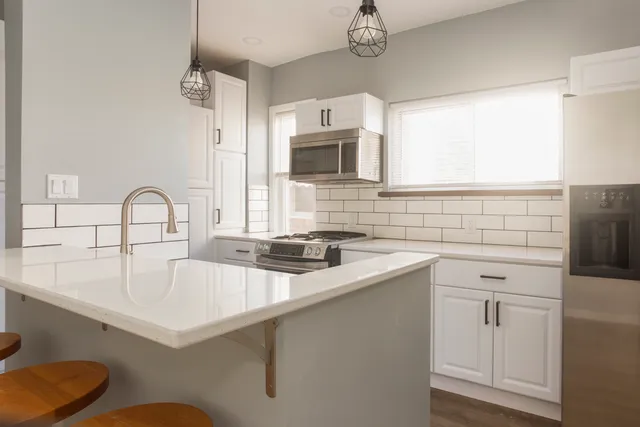 a kitchen with a sink a stove and cabinets