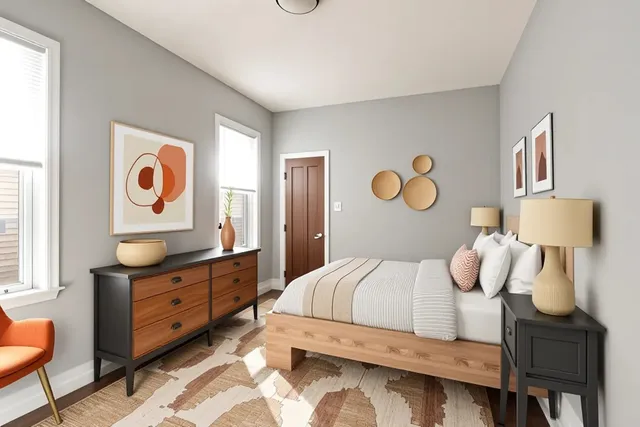 a bedroom with a bed and dresser with mirror