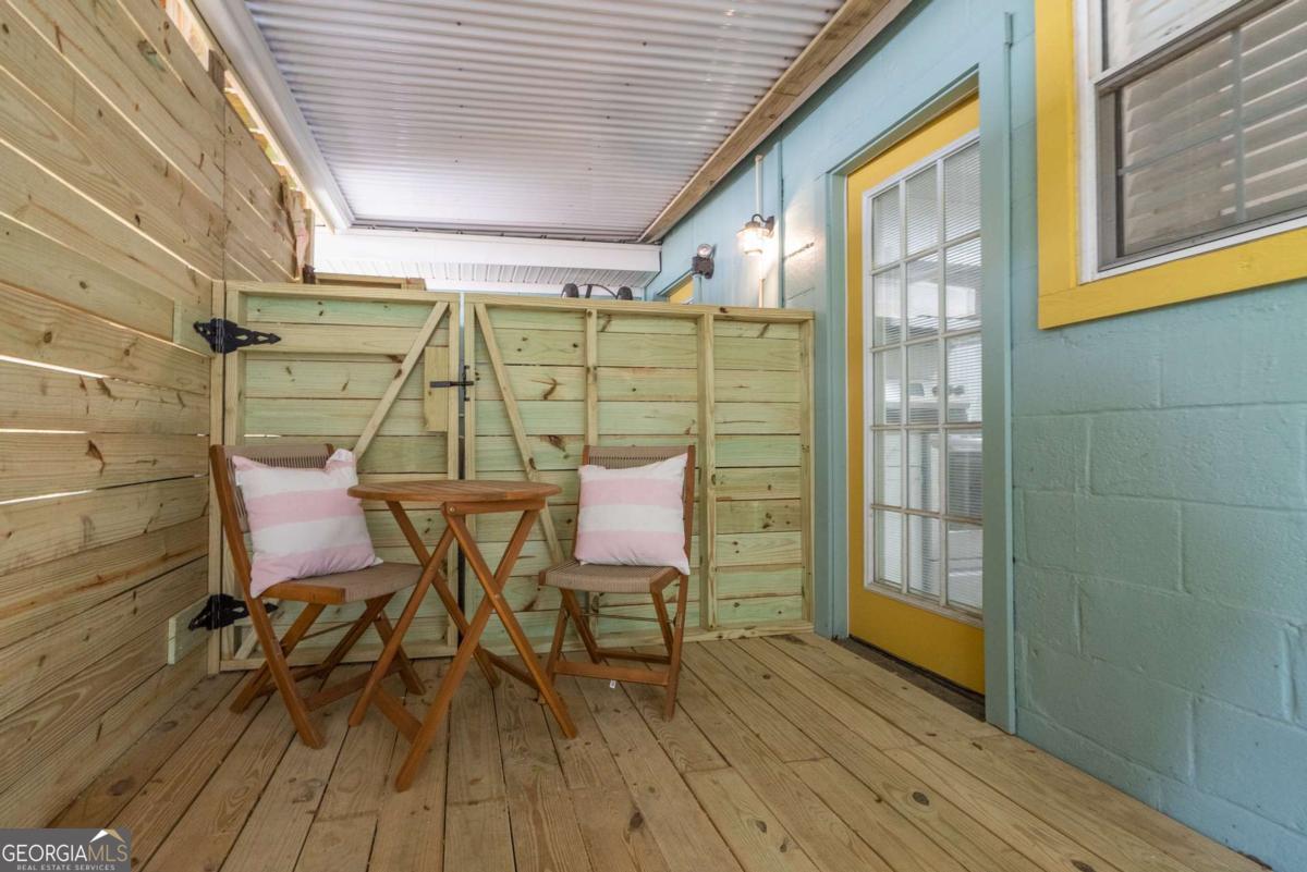 1413 2nd Avenue, Unit 4 Tybee Island, GA 31328 - Photo 27 of 32 a view of a patio with table and chairs and wooden floor