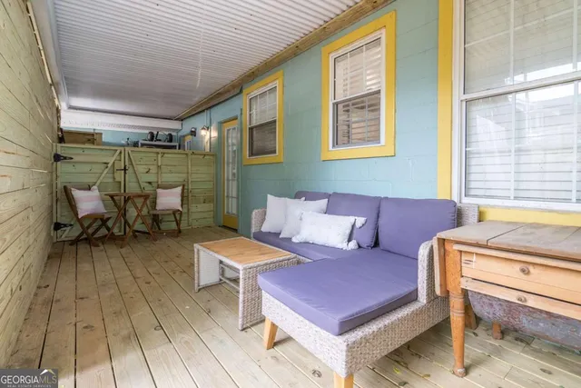 a view of a roof deck with wooden fence and a bench