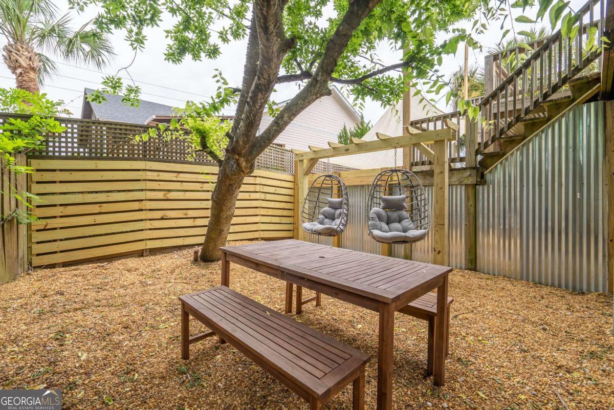 1413 2nd Avenue, Unit 4 Tybee Island, GA 31328 - Photo 29 of 32 a view of a roof deck with wooden fence and a bench