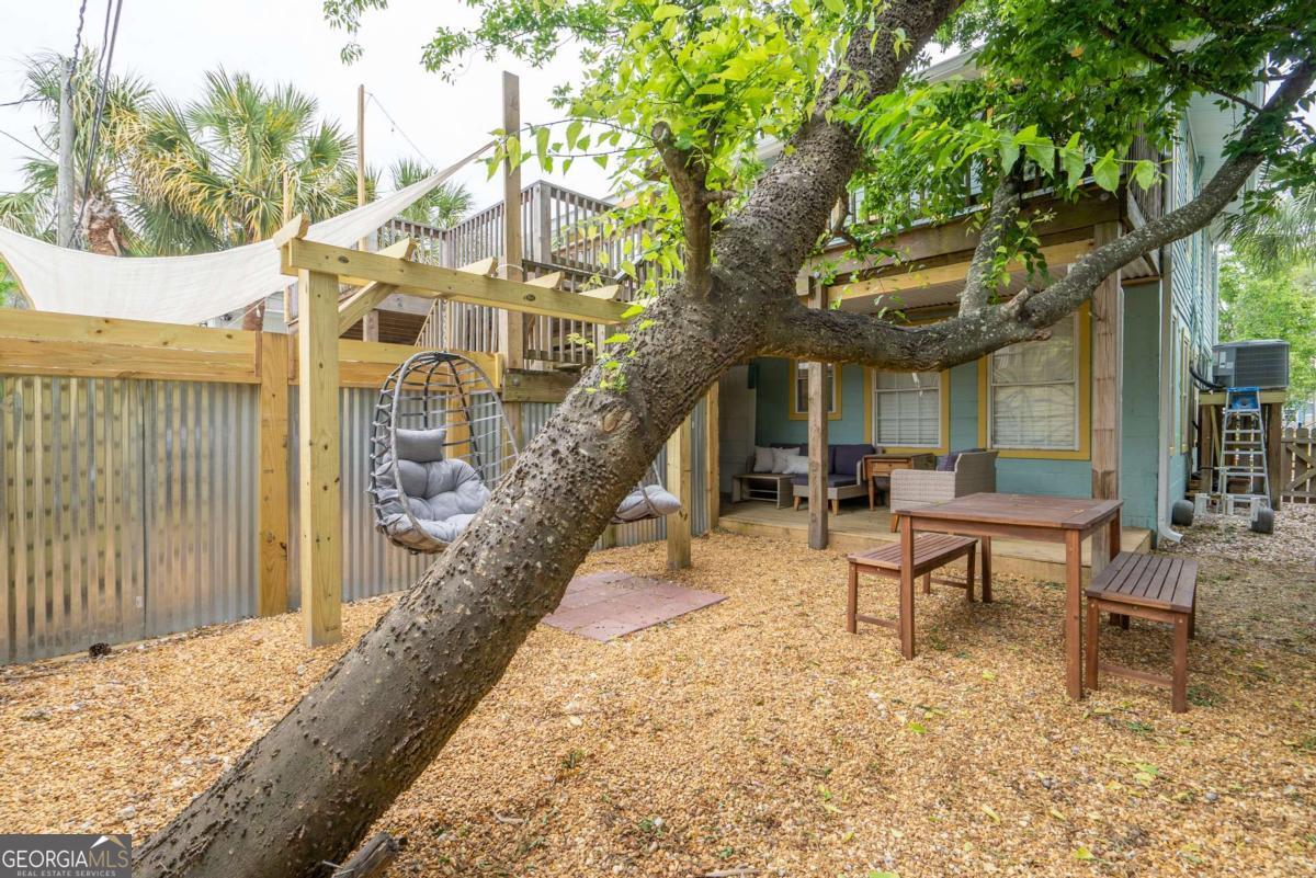 1413 2nd Avenue, Unit 4 Tybee Island, GA 31328 - Photo 31 of 32 a backyard of a house with table and chairs