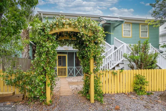 a front view of a house with a yard and potted plants