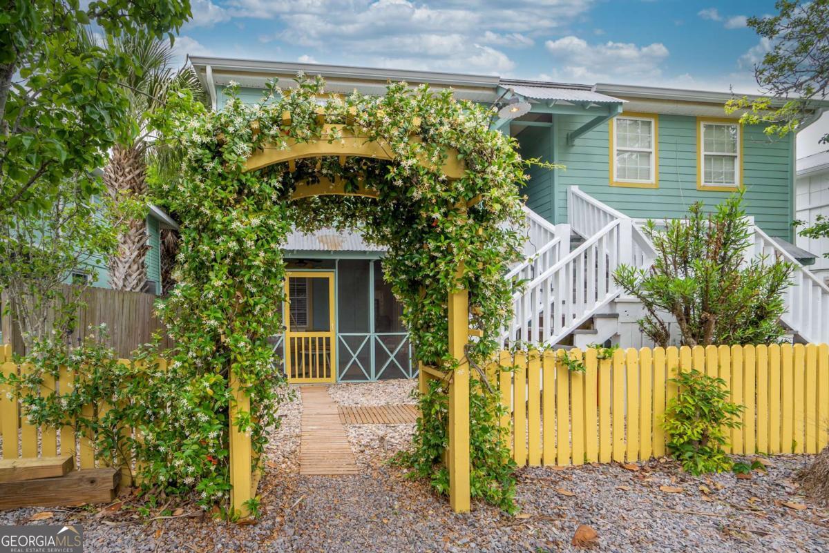 1413 2nd Avenue, Unit 4 Tybee Island, GA 31328 - Photo 4 of 32 a front view of a house with a yard and potted plants