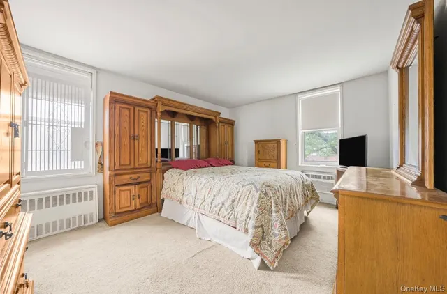 a spacious bedroom with a bed and a flat screen television