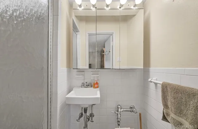 a kitchen with stainless steel appliances a refrigerator a stove a sink and white cabinets