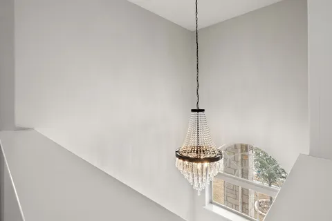 a view of a room with a chandelier fan