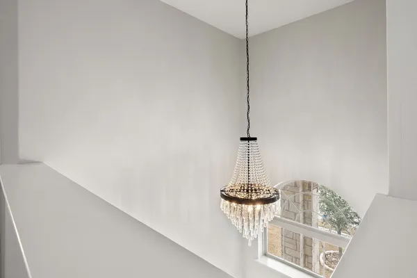 a view of a room with a chandelier fan